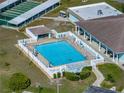 Aerial view of a community pool with lounge chairs, tables and lush landscaping in a sunny setting at 5016 Forest Crest Dr, Lakeland, FL 33810
