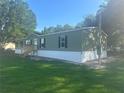Green single-story home with white accents, showcasing a well-manicured lawn at 5248 Rock Dove Trl, Lakeland, FL 33810