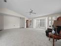 Neutral living room featuring plush carpeting, a ceiling fan, and bay window with serene views at 537 Eagle Run, Lakeland, FL 33809