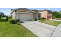Traditional home with a two-car garage, stone entry, and red window shutters at 5793 Dornich Dr, Auburndale, FL 33823