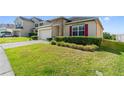 Beautifully landscaped front yard featuring green grass and trimmed hedges at 5793 Dornich Dr, Auburndale, FL 33823