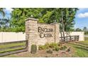 Stone entrance sign for English Creek community, surrounded by lush greenery and a wooden fence at 6372 English Creek Dr, Lakeland, FL 33811