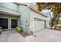 Lovely townhome entrance showcasing a brick paved driveway, a wreath on the front door, and a two-car garage at 6506 Sedgeford Dr, Lakeland, FL 33811