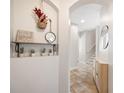 Hallway featuring tiled floors, arched doorways, decor shelves and views of the staircase at 6506 Sedgeford Dr, Lakeland, FL 33811