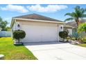 Exterior shot of a garage with a driveway and green landscaping at 7139 Cedarcrest Blvd, Lakeland, FL 33810