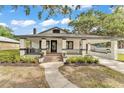 Inviting home features a covered front porch, well-manicured landscaping, and a charming walkway at 828 E Valencia St, Lakeland, FL 33805