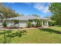 Inviting single-story home featuring mature trees, a well-manicured lawn, and a welcoming entrance at 12301 Jim Edwards Rd, Haines City, FL 33844