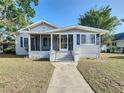 Inviting one-story home with a sunny yellow front door, screened-in porch and well-manicured lawn at 319 E Johnson Ave, Lake Wales, FL 33853