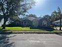 Street view of home showing stone accents, manicured lawn, and mature trees at 3300 Hawks Ridge Dr, Lakeland, FL 33810