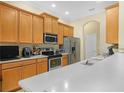 Well-lit kitchen featuring stainless steel appliances, light wood cabinets, and a spacious countertop at 3300 Hawks Ridge Dr, Lakeland, FL 33810