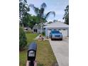 Charming single-story home with a well-manicured lawn and a blue truck in the driveway at 4734 Valley Hill Ct, Lakeland, FL 33813