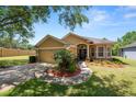 Charming single-story home featuring a manicured lawn, mature trees, and a two-car garage at 1167 Stoney Creek Blvd, Lakeland, FL 33811