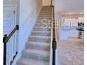 Carpeted staircase with decorative railing leads to the upper level of the home at 2303 Brassie Ct, Winter Haven, FL 33884