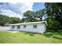 Lovely single-story home showcasing a well-manicured lawn and painted grey exterior at 2527 Dons Pl, Lakeland, FL 33801