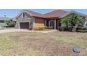 Single-story home with stone and siding exterior, two-car garage, and landscaped front yard at 5612 Vintage View Blvd, Lakeland, FL 33812