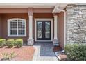 Elegant double front doors with white columns and manicured landscaping create a welcoming entrance at 5612 Vintage View Blvd, Lakeland, FL 33812