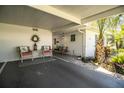 Inviting carport with seating area, decorated with a wreath and complemented by lush landscaping at 610 Cottage Ln, Lakeland, FL 33803