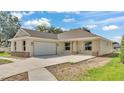 Lovely home featuring an attached two-car garage, front porch, stone accents, and a private driveway at 803 Allison Place, Bartow, FL 33830