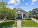 Inviting single-story home with a well-manicured lawn, landscaping, and a charming covered porch at 117 Palmola St, Lakeland, FL 33803