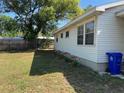 Lush backyard featuring green grass, a wood fence, and the side of the home at 1226 N Brunnell Pkwy, Lakeland, FL 33805