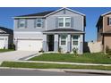 Charming two-story home with a well-manicured lawn, landscaping, and a two-car garage at 1280 Denali Dr, Winter Haven, FL 33880