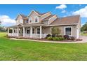 Inviting two-story home featuring a charming wrap-around porch and landscaped front yard at 150 Berkley Knights Dr, Auburndale, FL 33823