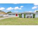 Charming single-story home featuring a red front door and well-manicured landscaping at 170 Browning Cir, Winter Haven, FL 33884