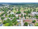 Aerial view of a neighborhood showcasing the house, mature trees, and proximity to a golf course under a sunny sky at 1850 Martin Luther King, Jr. E Blvd, Bartow, FL 33830
