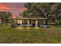 A covered patio is attached to the home, with outdoor furniture, and partially fenced yard at 3728 Old Polk City Rd, Lakeland, FL 33809