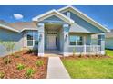 Inviting front porch with white railing and a landscaped garden leading to the front door at 4027 Tullamore Ln, Auburndale, FL 33823