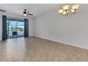 Open living room with tile flooring, neutral paint, ceiling fan and sliding glass door at 4089 Shade Tree Ln, Lakeland, FL 33812