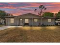 Charming white brick home with a cozy front porch and well-maintained lawn at dusk at 435 Lyle Pkwy, Bartow, FL 33830