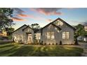 Twilight view of a beautiful home featuring a manicured lawn and a stone facade, creating a welcoming curb appeal at 5087 Cliffside Drive, Lakeland, FL 33813