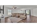 Spacious living room featuring a large sectional sofa, ceiling fan, and sliding glass doors to the backyard at 613 Sarner Pass Way, Winter Haven, FL 33881
