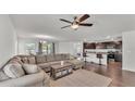 Open-concept living room and kitchen area, with a large sectional sofa and bar seating at the kitchen counter at 613 Sarner Pass Way, Winter Haven, FL 33881