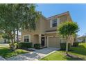 Charming two-story home features a neutral facade, well-manicured landscaping, and a cozy front porch at 8931 Sugar Palm Rd, Kissimmee, FL 34747