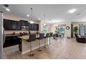 Open-concept kitchen with island seating flows into a dining area, creating an ideal space for entertaining at 8931 Sugar Palm Rd, Kissimmee, FL 34747