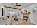 Bright living room featuring modern ceiling fan, a fireplace, and wooden beam accents at 919 S Missouri Ave, Lakeland, FL 33803