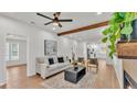 Bright living room featuring a comfortable sofa, modern ceiling fan, and wooden beam accents at 919 S Missouri Ave, Lakeland, FL 33803