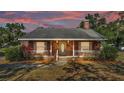 Charming single-story brick home featuring a welcoming front porch and meticulously maintained landscaping at 1055 Sunset Ave, Bartow, FL 33830