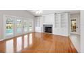 Bright living room with wood floors, fireplace, built-ins, and French doors to the pool at 1104 Kells Ct, Lakeland, FL 33813