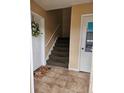Tiled hallway with carpeted stairs, white door, and a decorative wreath at 1920 E Edgewood Dr # T6, Lakeland, FL 33803