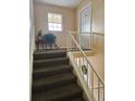 Carpeted stairwell with white railings leading to an upper level at 1920 E Edgewood Dr # T6, Lakeland, FL 33803