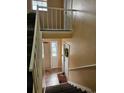 Carpeted stairwell with white railings and a view of the entryway with a floral wreath at 1920 E Edgewood Dr # T6, Lakeland, FL 33803