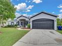 View of the home's charming exterior with an attached two car garage and a long private driveway at 2033 Normandy Heights Dr, Winter Haven, FL 33880
