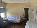 Living room with a futon, chair, and damaged walls, needs renovation at 445 Choctaw Ave, Lakeland, FL 33815