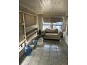 Enclosed porch featuring tile floors, multiple windows, and weathered furniture at 445 Choctaw Ave, Lakeland, FL 33815