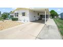 Side view of a well-maintained home featuring a long driveway and covered carport at 5027 Forest Crest Dr, Lakeland, FL 33810