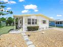 Quaint single-story home with a covered carport and pathway through a rock garden and lush landscaping at 5027 Forest Crest Dr, Lakeland, FL 33810