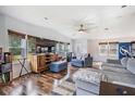 Comfortable living room featuring a large TV, wood floors, and stylish furniture at 7011 Tall Pine Rd, Polk City, FL 33868